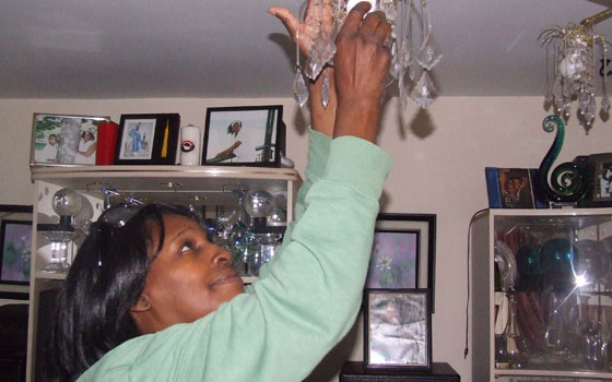 Elsie Brown, a resident of the Madison Park Village housing complex in Roxbury, installs a compact fluorescent light bulb on Friday, Sept. 11, 2009. The Episcopal Diocese of Massachusetts helped install energy-efficient light bulbs in Madison Park and at St. John St. James Episcopal Church. Photo By Talia Whyte